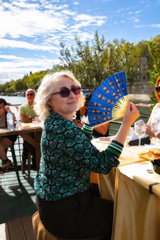 A table set on board, glasses and a platter facing the Seine