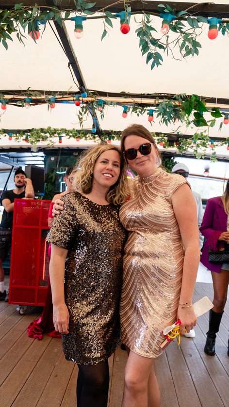 Two guests in sequinned dresses on the deck