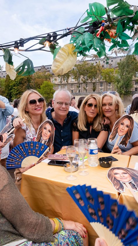 A table of guests in front of the Louvre, glasses and Céline fans